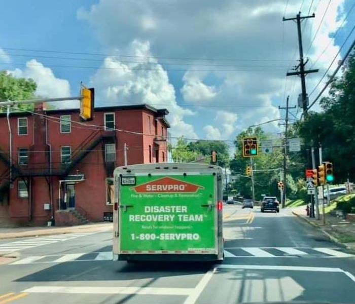 A SERVPRO truck pulling a trailer on a busy street.