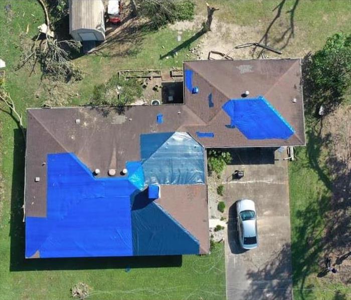 houses with blue tarp on the roof 