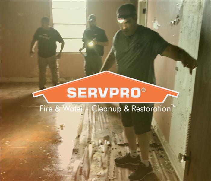 SERVPRO employees walking through water damaged room