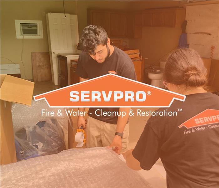 SERVPRO Employees working on wrapping furniture to move